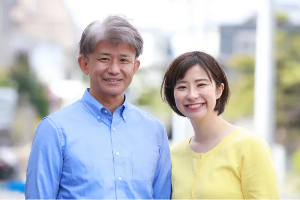 若い女性と中年の男性が並んで笑う様子