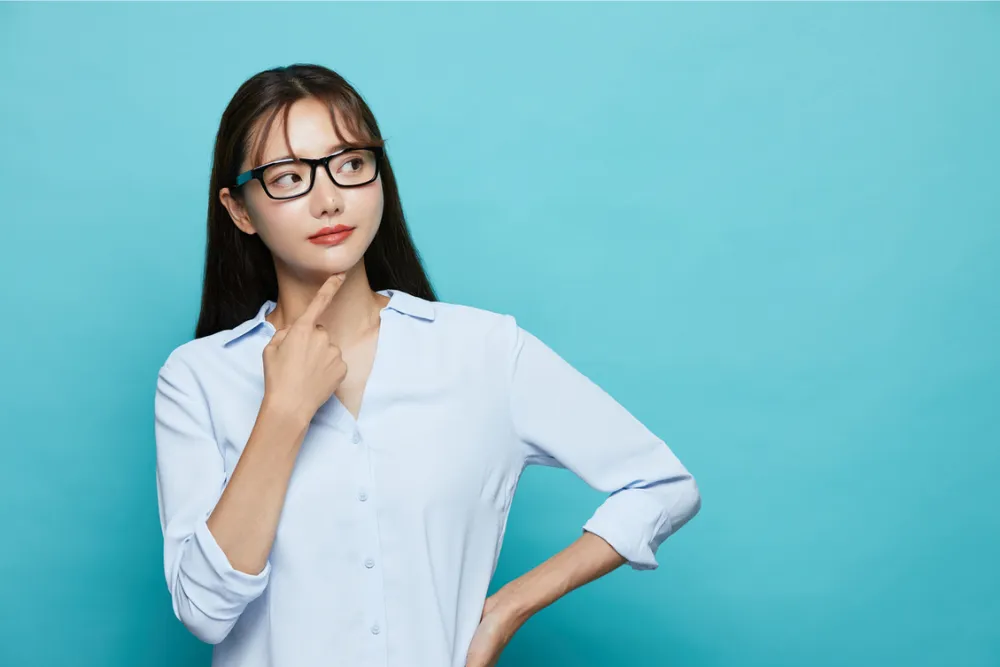 顎に手を当て考える女性