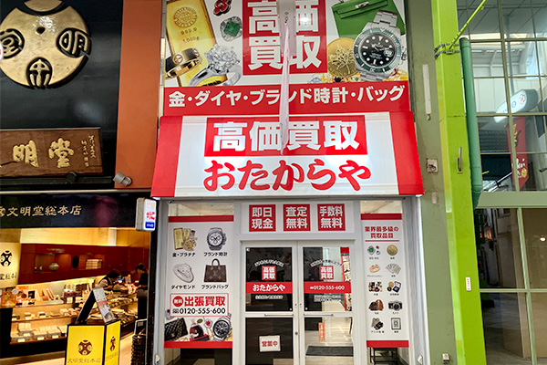 向かって左側に見えるカステラ屋「文明堂」さんのお隣が、「おたからや佐世保四ヶ町商店街店」です。