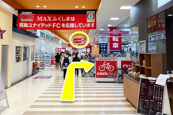 入店し真っ直ぐ進むと、ATMの案内看板がございますので、そちらを右に曲がります。