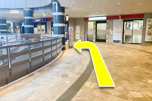 左手にエスカレーターが見えてくるので、エスカレーターを降りてください。