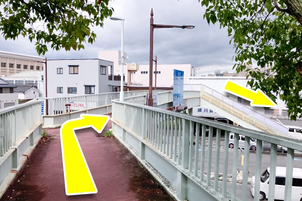 進んで行くと歩道橋があるので、歩道橋を上がっていき、突き当たりの階段を降りてください。