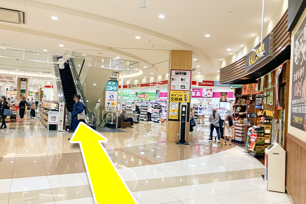 A玄関から入り右手にすすみ、カルディー前のエスカレーターで2階に上がってください。