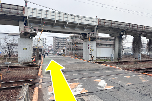 踏切を渡りまっすぐ進んでください。
