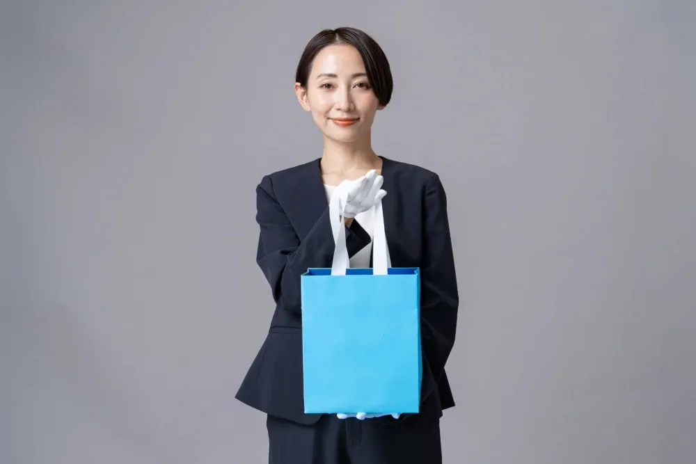 紙袋を渡す女性