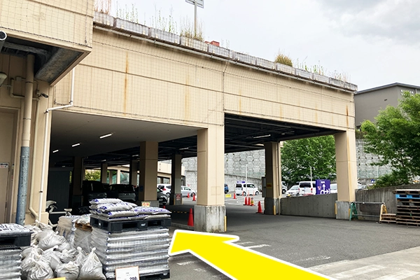 右側に進んでいくと、写真のような屋根付きの駐車場と歩行者用通路がありますのでそこを進みます。