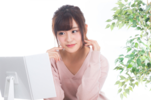 鏡を見るピンクの服の女性