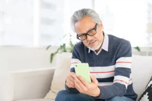 スマホを触る高齢の男性