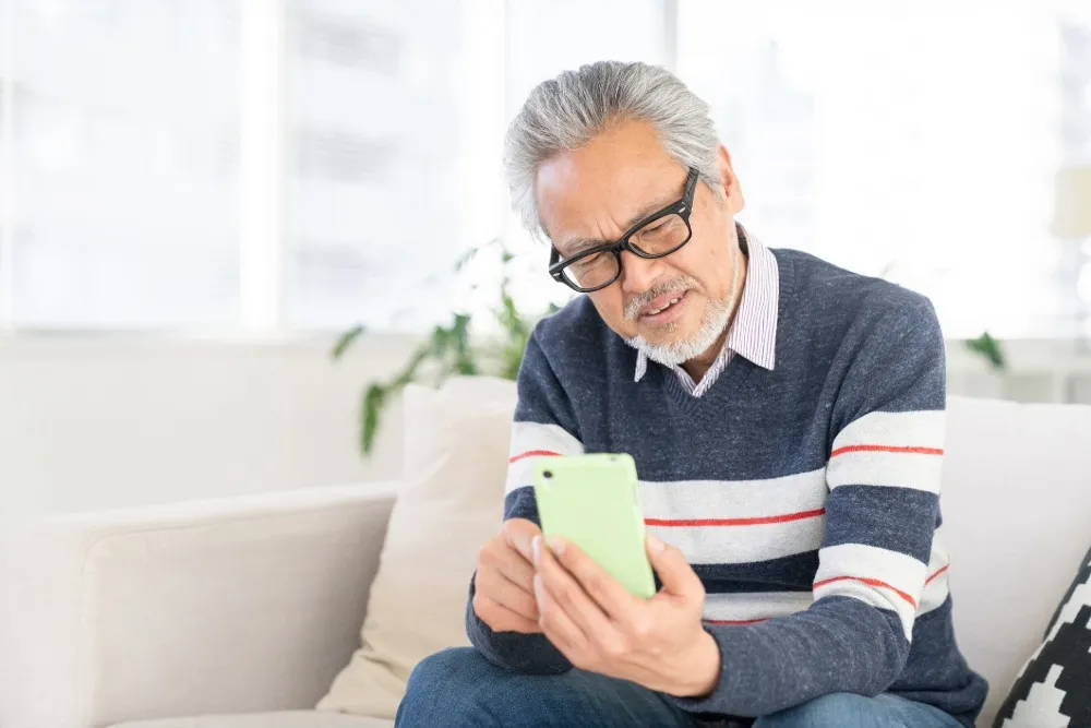 スマホを触る高齢の男性
