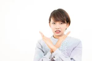 両手でバツをする女性