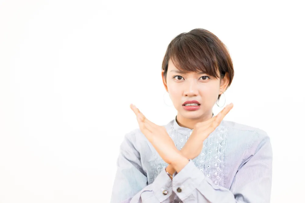 両手でバツをする女性