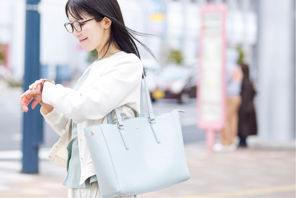 時計を見る通勤女性