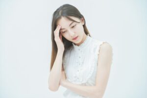 考える白い服の女性