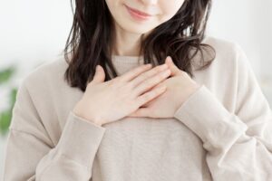 胸に手を当てる女性