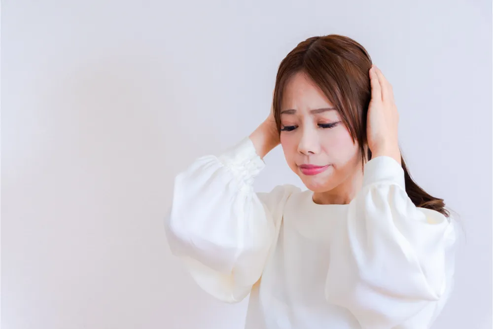頭をかかえる女性