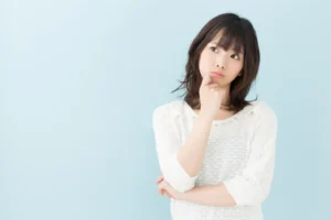 顎に手を当て考える女性