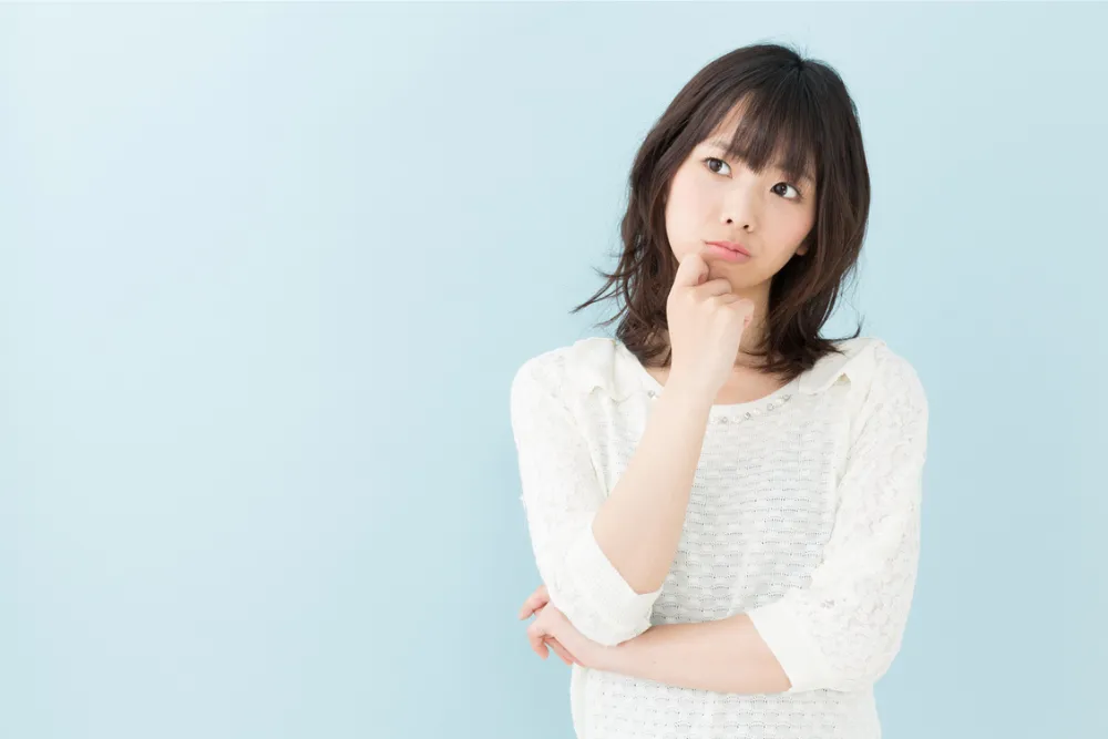 顎に手を当て考える女性