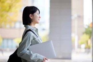パソコンを持った横向きの女性