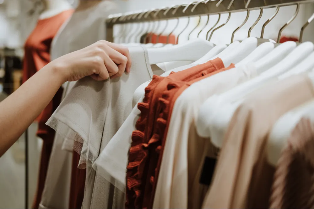 服を手に取る女性の手