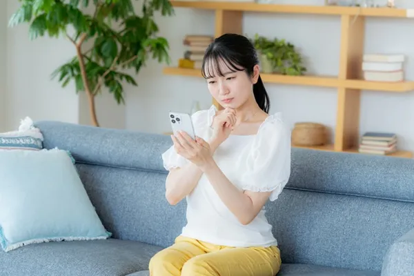 スマホをみて首をかしげる女性
