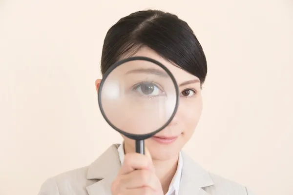 虫眼鏡で見る女性