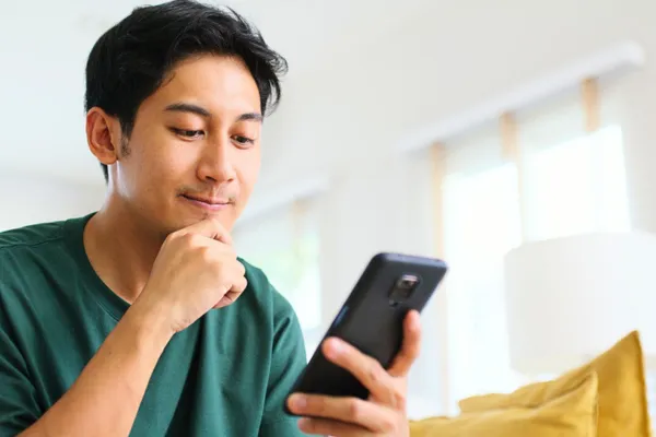 スマホを見て考える男性