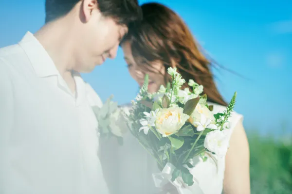 女性と男性が向き合い花束を持っている様子