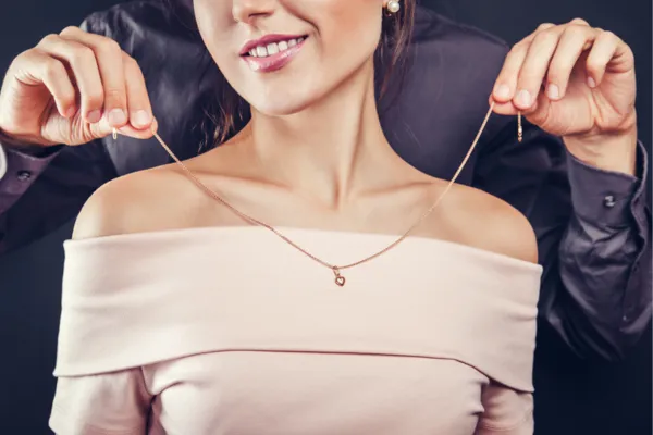 ハートのネックレスを男性につけられている女性