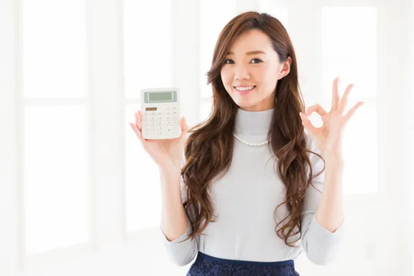 電卓をもって笑う女性