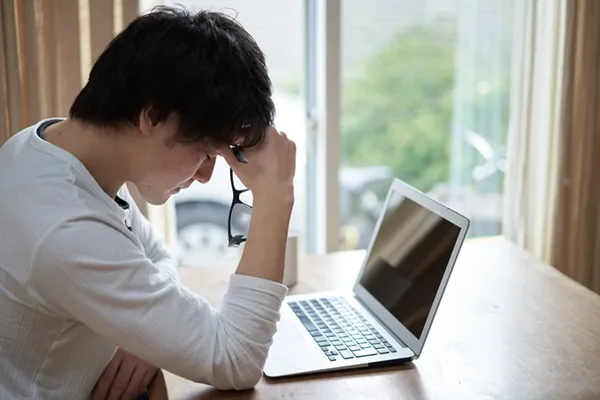 パソコンの前でがっかりする男性