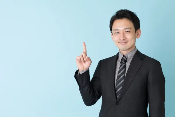 指をさしているスーツの男性