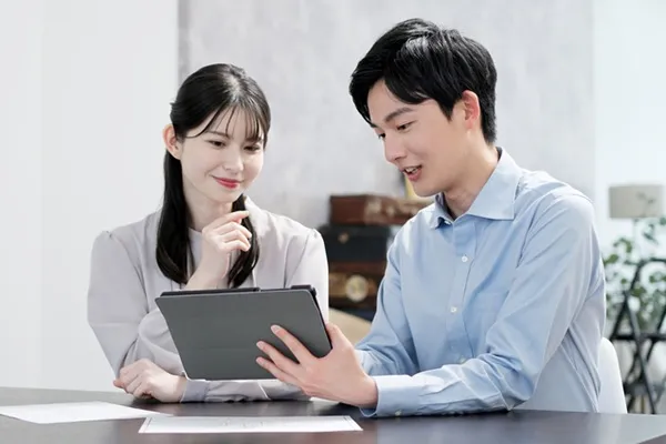 タブレットを持って話し合う男女