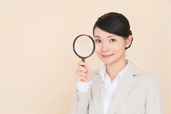 虫眼鏡をもつ女性