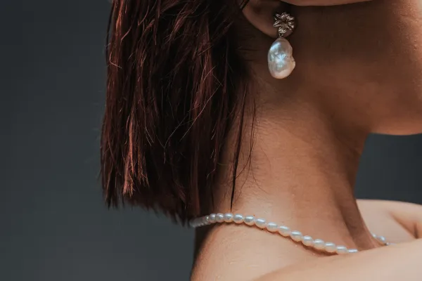 パールのピアスとネックレスをつけた女性の横顔
