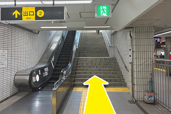 2番出口の階段（またはエスカレーター）を上り、地上へ出ます。